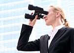 Business woman looking through binoculars 