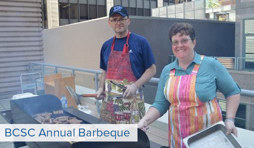 Two people cooking over a grill